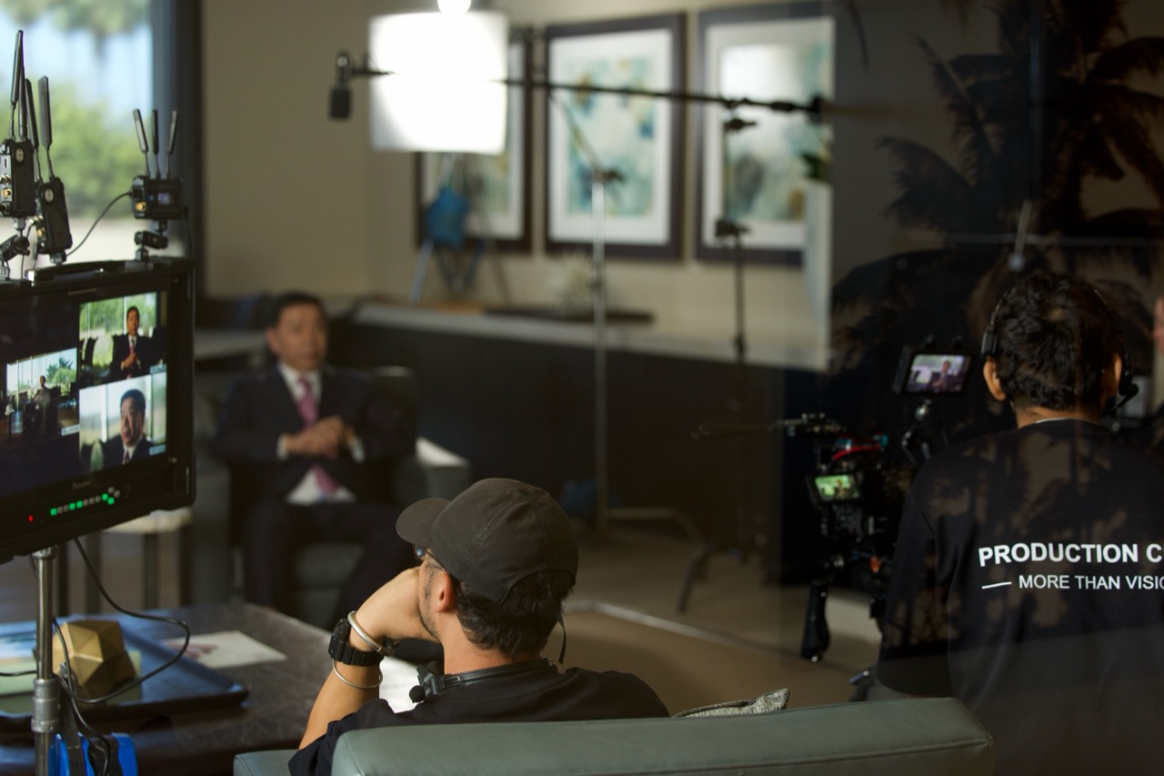 Behind the scenes of an interview shoot with cameras, lighting, production monitors and crew